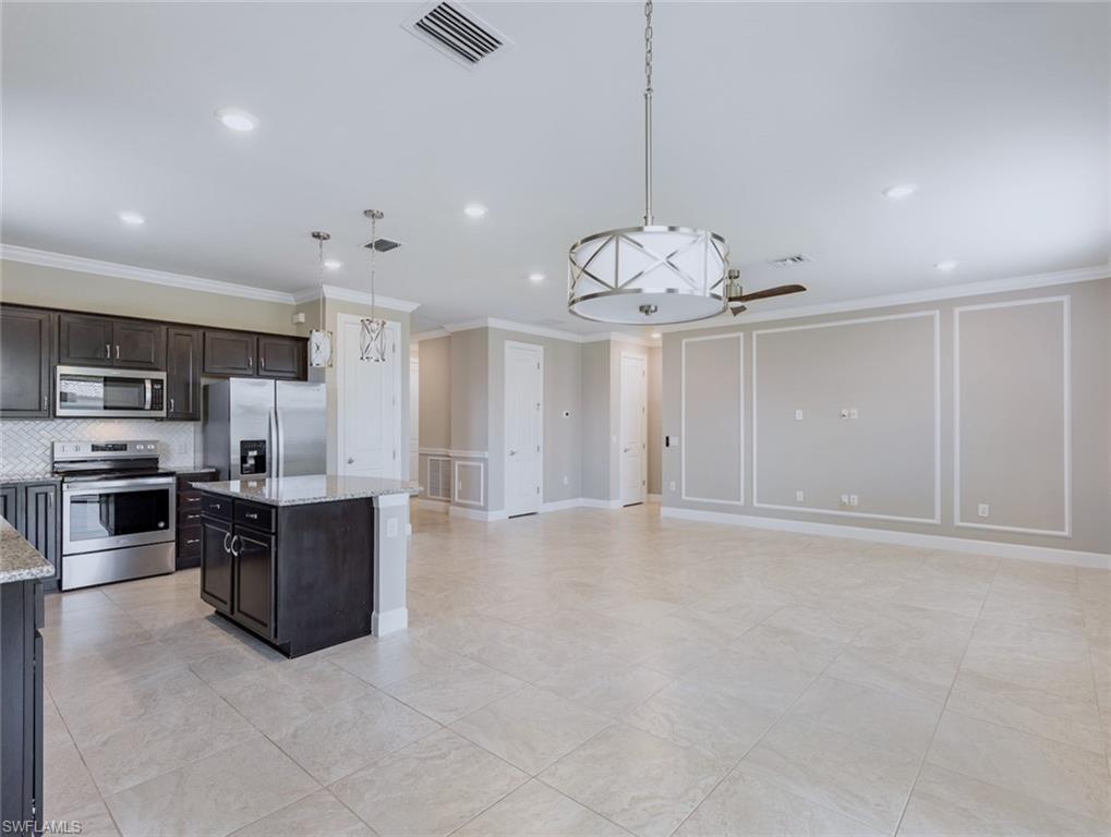19953 Beverly Park Road Estero, FL 33928 - Photo 5 of 35 a large kitchen with stainless steel appliances granite countertop a stove and cabinets