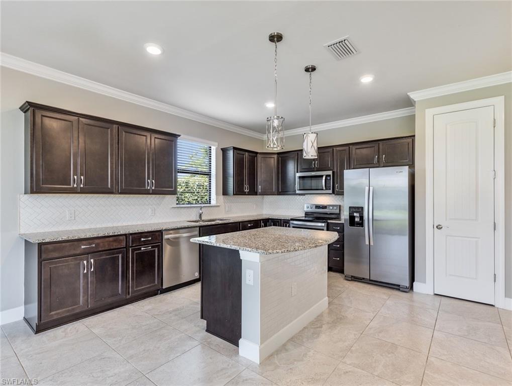 19953 Beverly Park Road Estero, FL 33928 - Photo 7 of 35 a kitchen with stainless steel appliances granite countertop a stove refrigerator sink and microwave