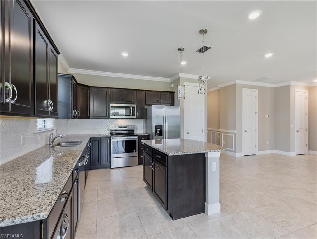 19953 Beverly Park Road Estero, FL 33928 - Photo 8 of 35 a kitchen with stainless steel appliances granite countertop a sink stove and refrigerator