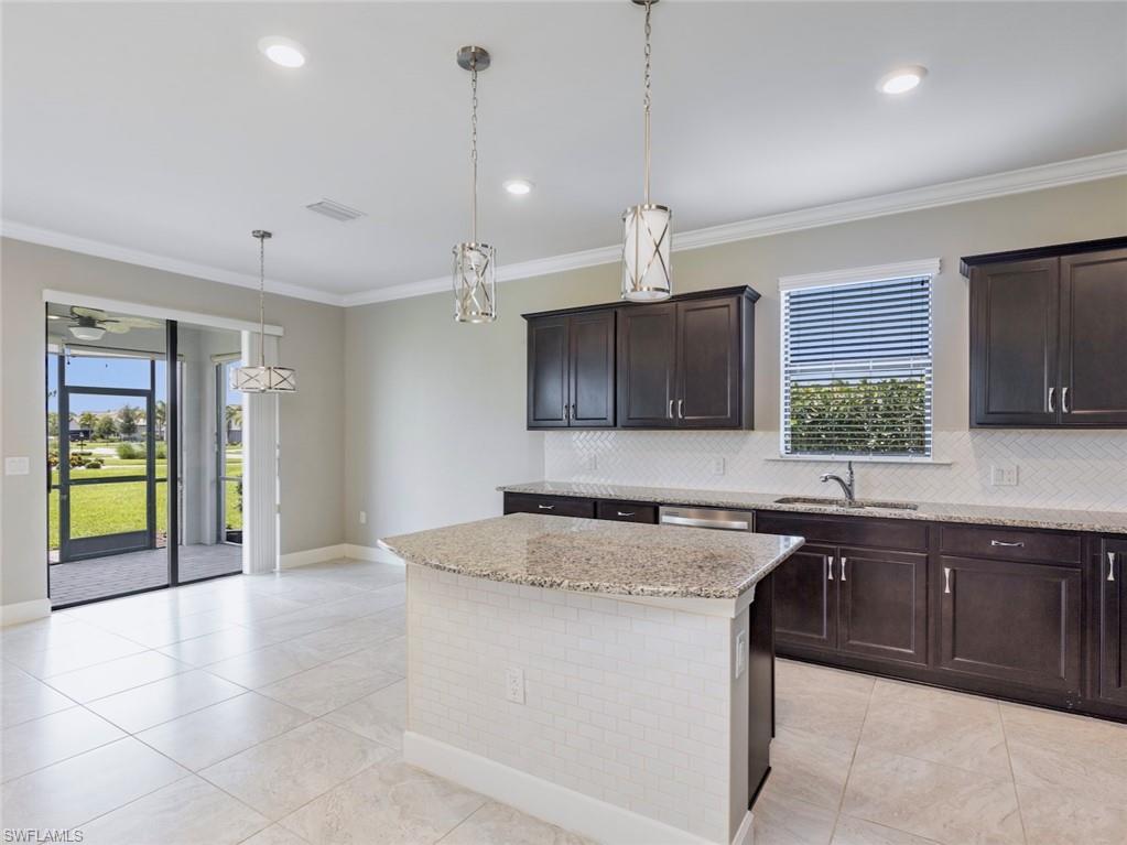 19953 Beverly Park Road Estero, FL 33928 - Photo 9 of 35 a kitchen with kitchen island granite countertop a sink a counter top space appliances and cabinets