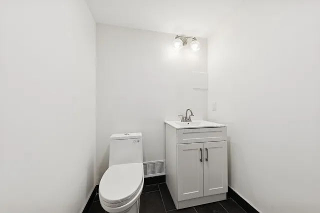 a bathroom with a toilet a sink and mirror
