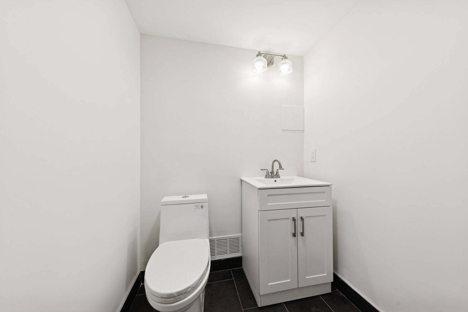282 Convent Avenue, Unit 1 Manhattan, NY 10031 - Photo 12 of 14 a bathroom with a toilet a sink and mirror