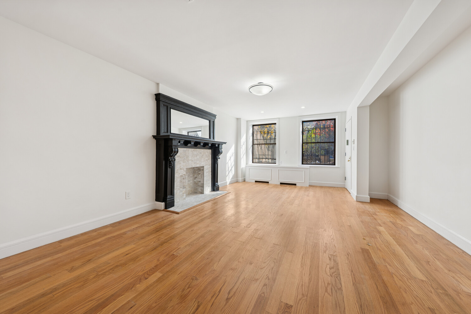 282 Convent Avenue, Unit 1 Manhattan, NY 10031 - Photo 2 of 14 a big room with wooden floor and windows