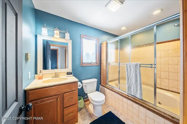 a bathroom with a toilet a sink and a large mirror