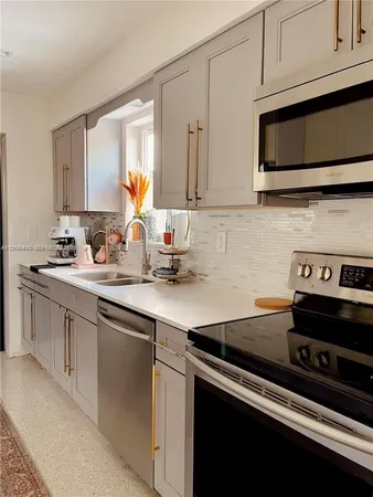 a kitchen with stainless steel appliances granite countertop a sink stove and microwave