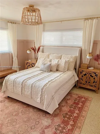 a bedroom with a bed next to a window and a chandelier