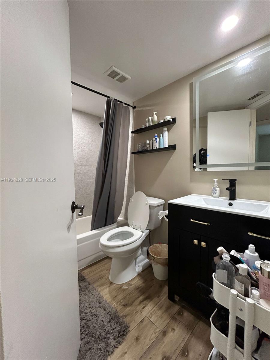 8977 Wiles Road, Unit 208 Coral Springs, FL 33067 - Photo 15 of 28 a bathroom with a sink vanity mirror and toilet