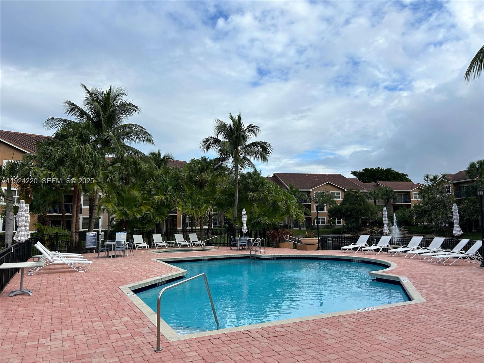 8977 Wiles Road, Unit 208 Coral Springs, FL 33067 - Photo 17 of 28 a view of a swimming pool with a patio