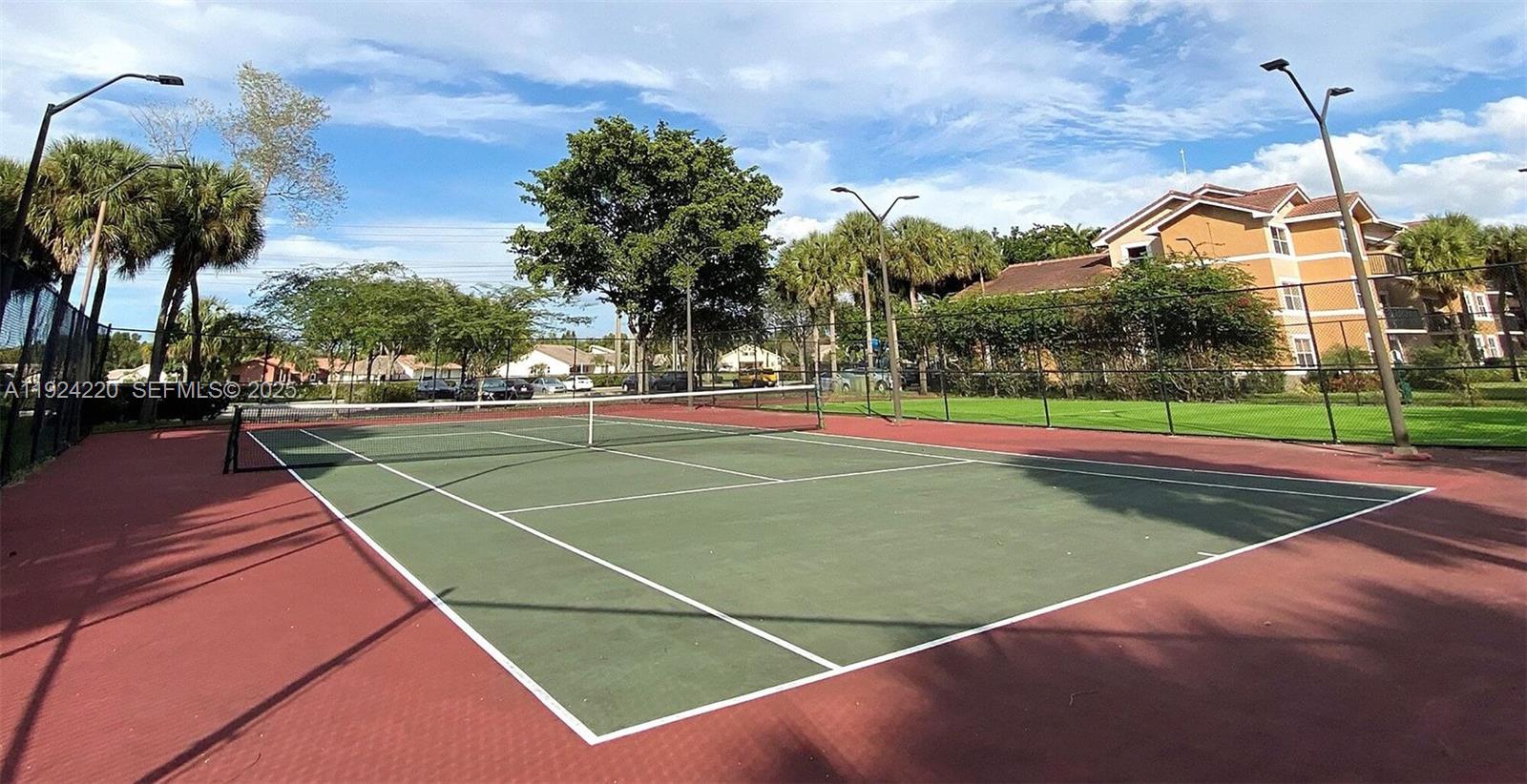 8977 Wiles Road, Unit 208 Coral Springs, FL 33067 - Photo 22 of 28 a view of a tennis ground with large trees