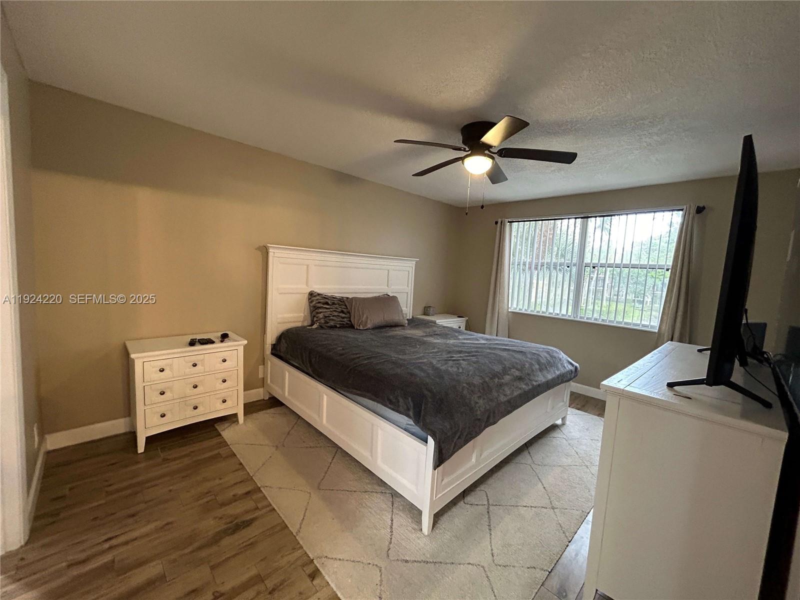 8977 Wiles Road, Unit 208 Coral Springs, FL 33067 - Photo 9 of 28 a bedroom with a bed and a flat screen tv