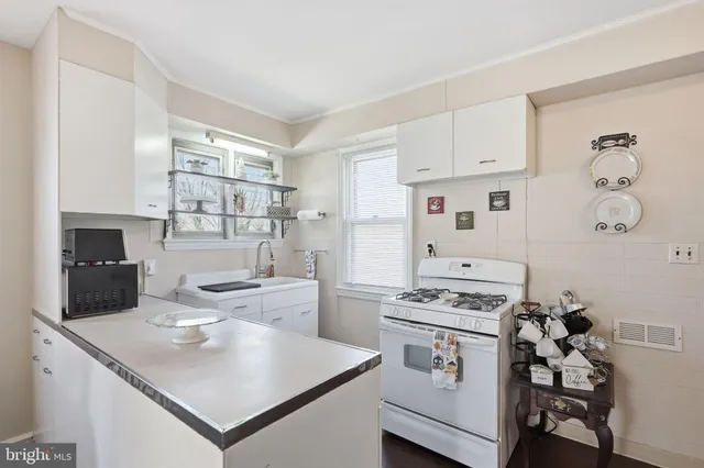 a kitchen with white cabinets and appliances