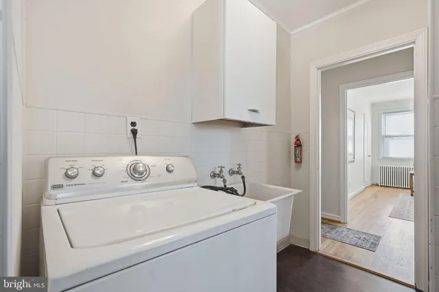 a view of washer and dryer with bathroom in the background