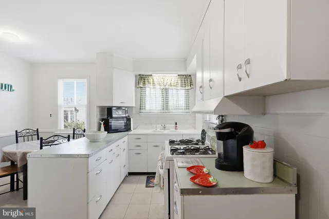 a kitchen with a sink a stove and cabinets