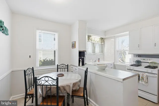 a kitchen with a dining table chairs and white cabinets