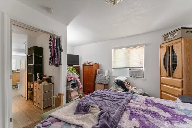 a bedroom with a bed and a refrigerator