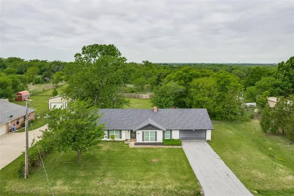an aerial view of residential houses with outdoor space and trees