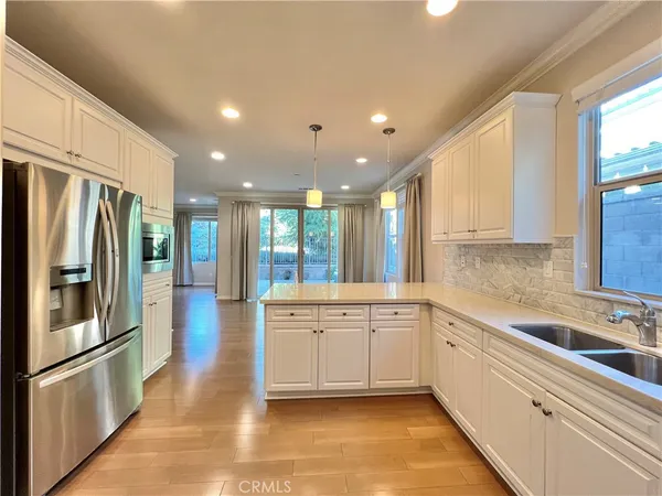 a large kitchen with stainless steel appliances lots of counter space and a sink