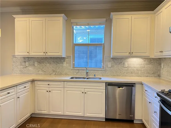 a kitchen with white cabinets and sink
