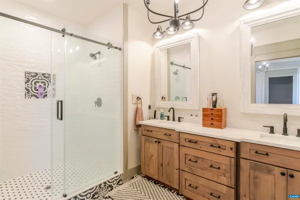 a bathroom with a shower sink vanity and mirror