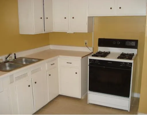 a kitchen with granite countertop white cabinets and white appliances