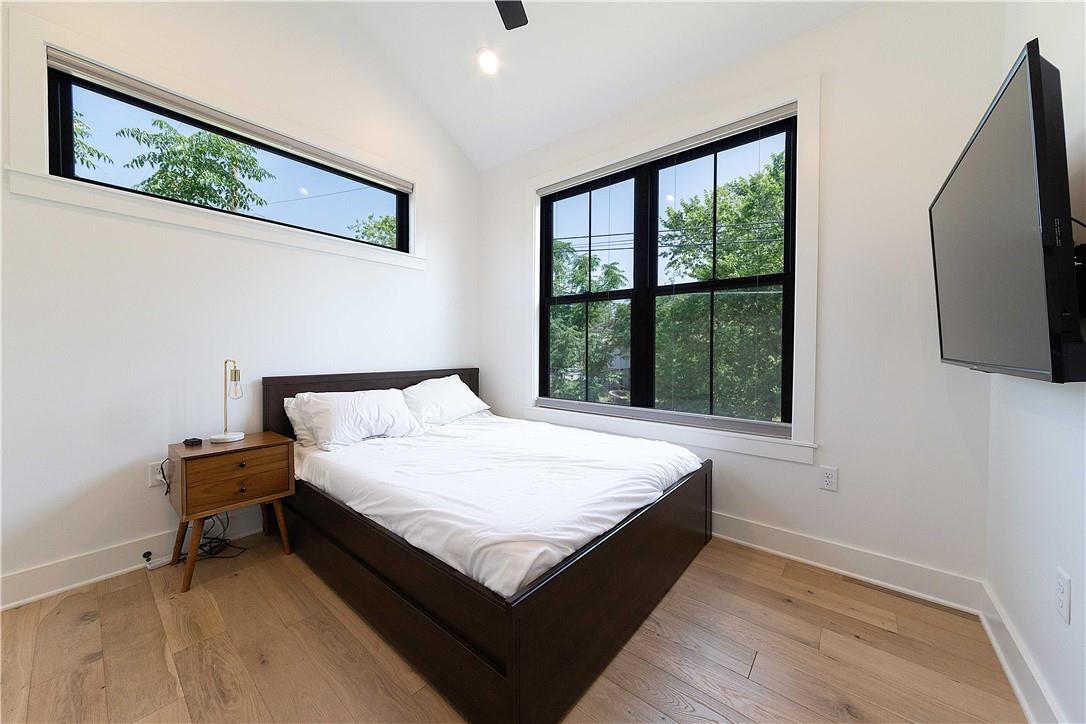 2002 East 9th Street, Unit 2 Austin, TX 78702 - Photo 16 of 32 Hardwood floors and generous windows elevate this serene bedroom space.