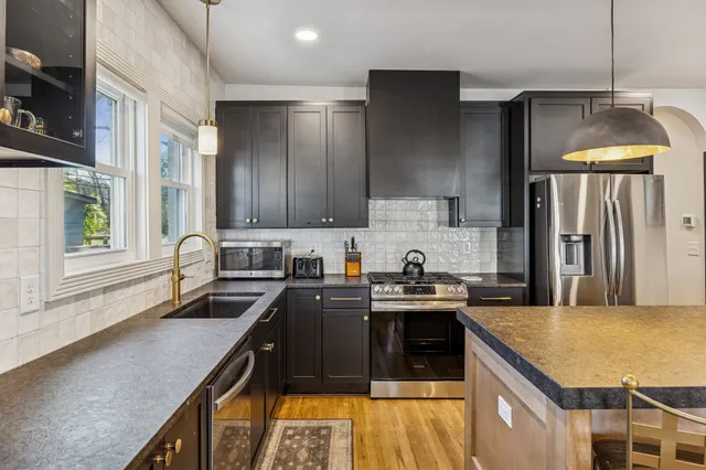 a kitchen with stainless steel appliances granite countertop a sink stove and refrigerator