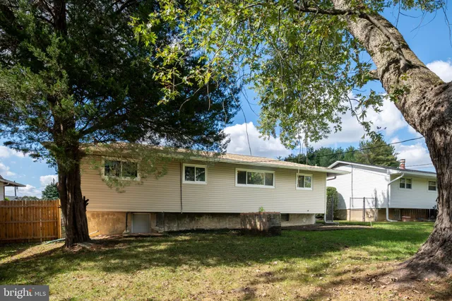 a view of a house with a big yard and large trees