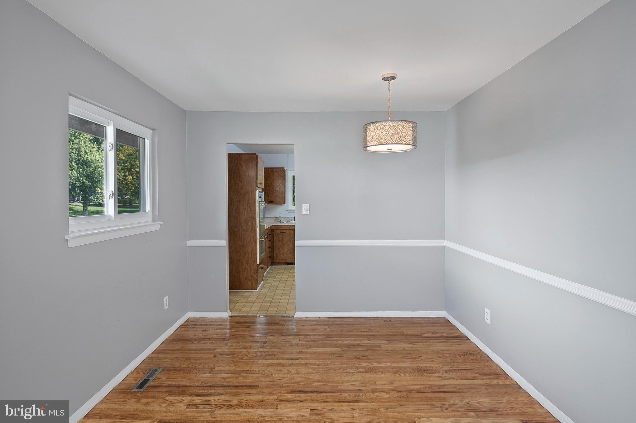 3947 Setonhurst Road Baltimore, MD 21208 - Photo 7 of 30 a view of an empty room with wooden floor and a window
