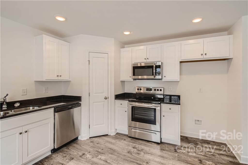 1704 Mooresville Road Salisbury, NC 28147 - Photo 5 of 9 a kitchen with white cabinets and black appliances