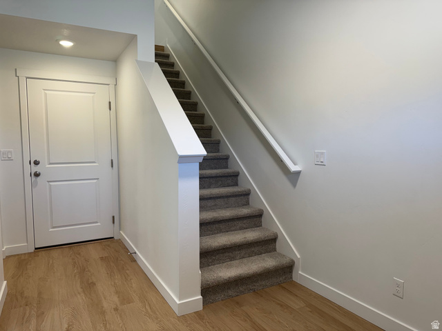 1472 North 1875 West, Unit 151 Layton, UT 84041 - Photo 2 of 20 Staircase with carpeted treads and risers, featuring a white handrail and newel post