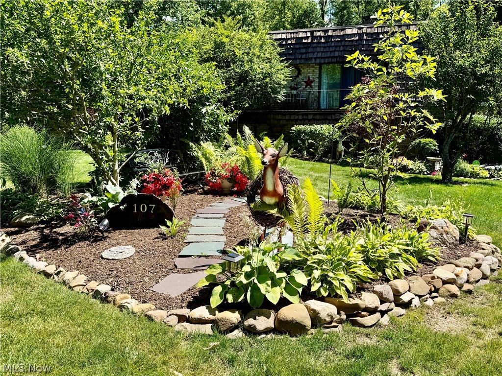 171 Granger Road, Unit 107 Medina, OH 44256 - Photo 2 of 41 Manicured front yard with stone-edged garden beds and a stepping stone pathway in the center island.