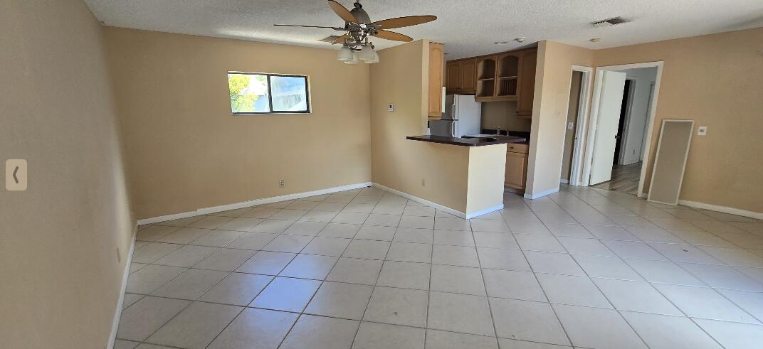 1 Crossings Circle, Unit F Boynton Beach, FL 33435 - Photo 4 of 11 an empty room with wooden floor and a ceiling fan