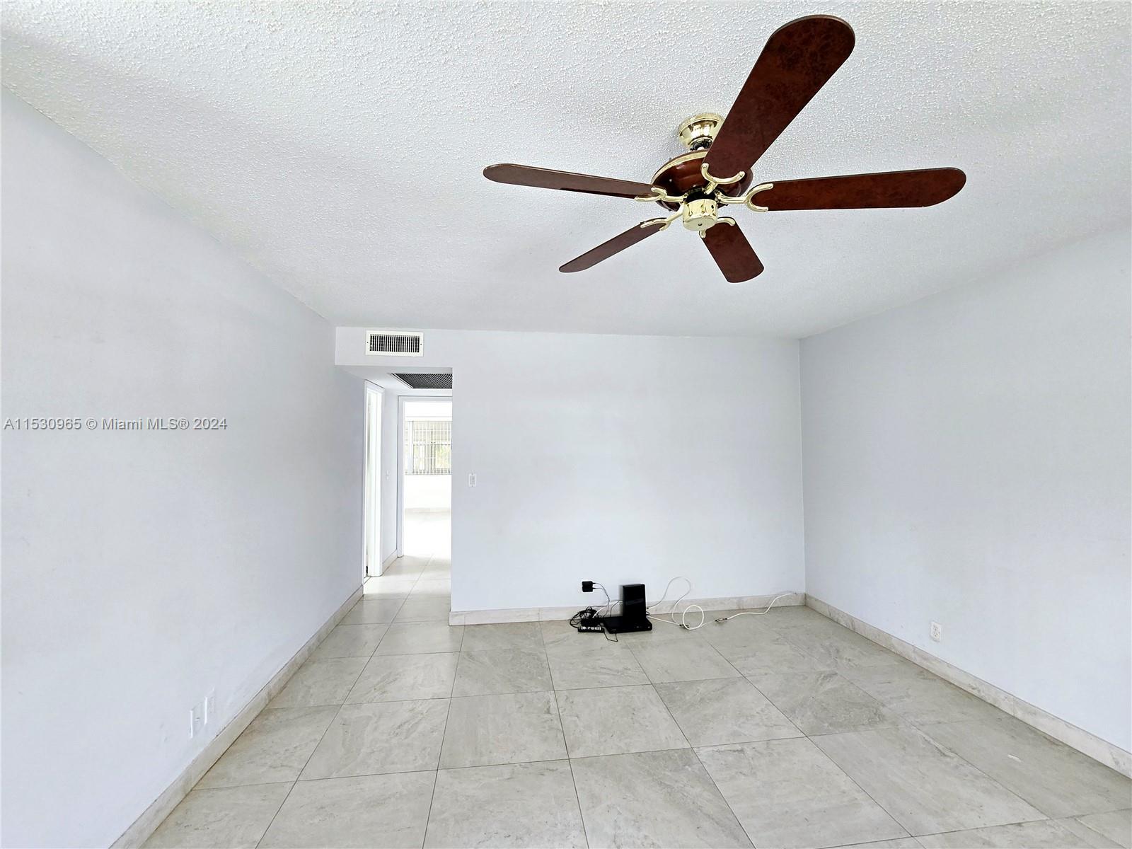 an empty room with windows and ceiling fan