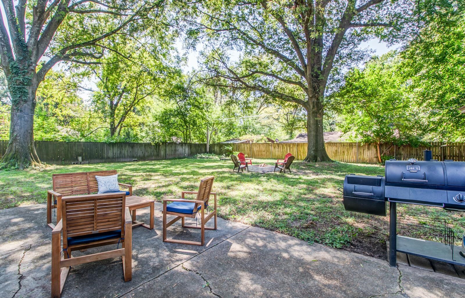 1377 Marcia Road Memphis, TN 38117 - Photo 20 of 24 a backyard of a house with table and chairs a fire pit and a large tree