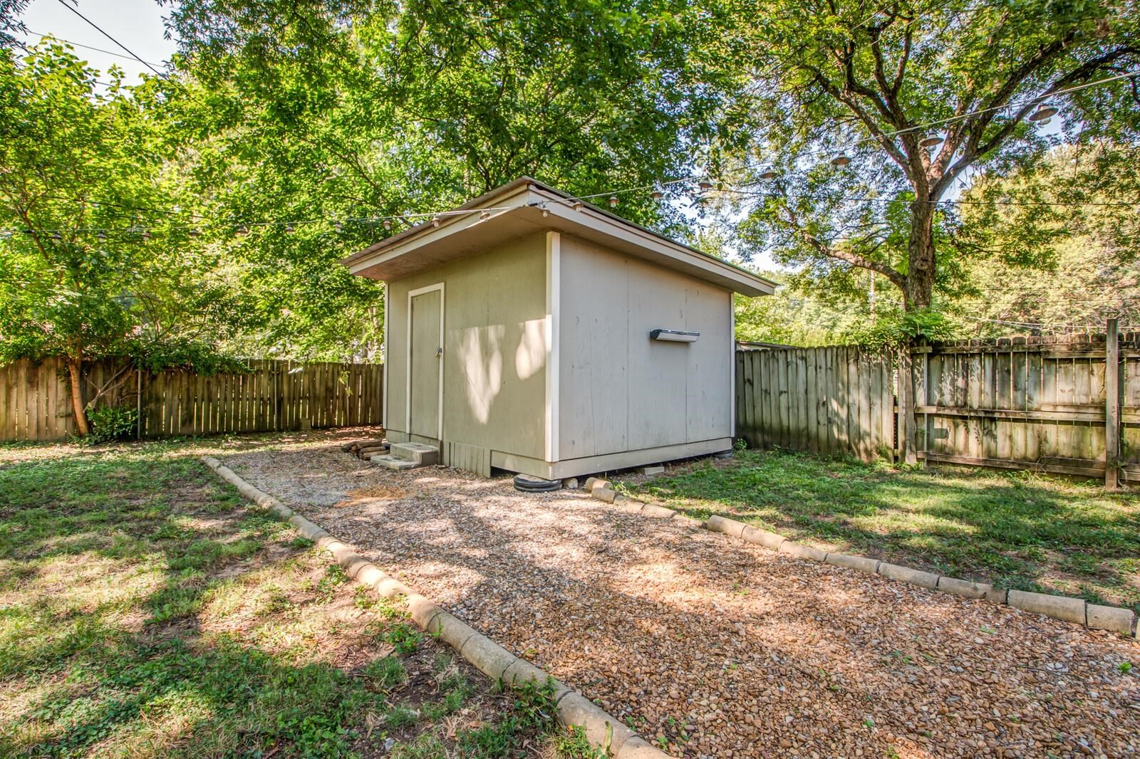 1377 Marcia Road Memphis, TN 38117 - Photo 23 of 24 a backyard of a house with large trees and wooden fence