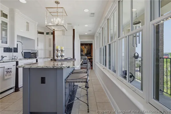 a kitchen with stainless steel appliances kitchen island granite countertop a refrigerator and a sink