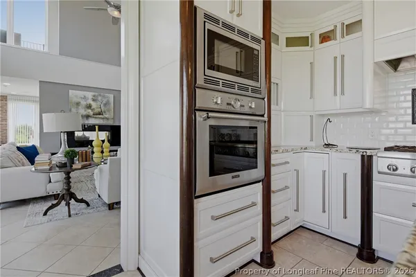 a kitchen with stainless steel appliances a stove and white cabinets