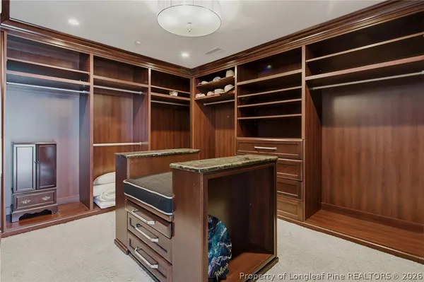 a view of walk in closet with clothes and shoes