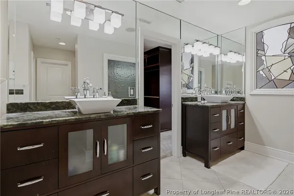 a bathroom with a granite countertop double vanity sink and mirror