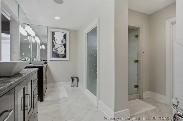 a spacious bathroom with a granite countertop sink a mirror and a shower
