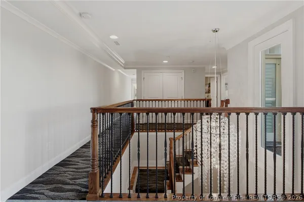 a view of staircase with railing and white walls
