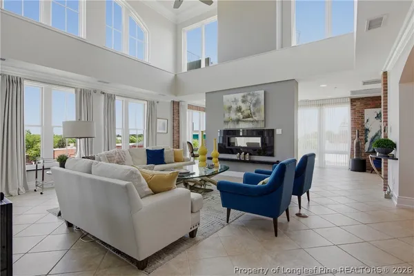 a living room with furniture a flat screen tv and a fireplace