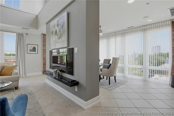 a living room with furniture a flat screen tv and a large window