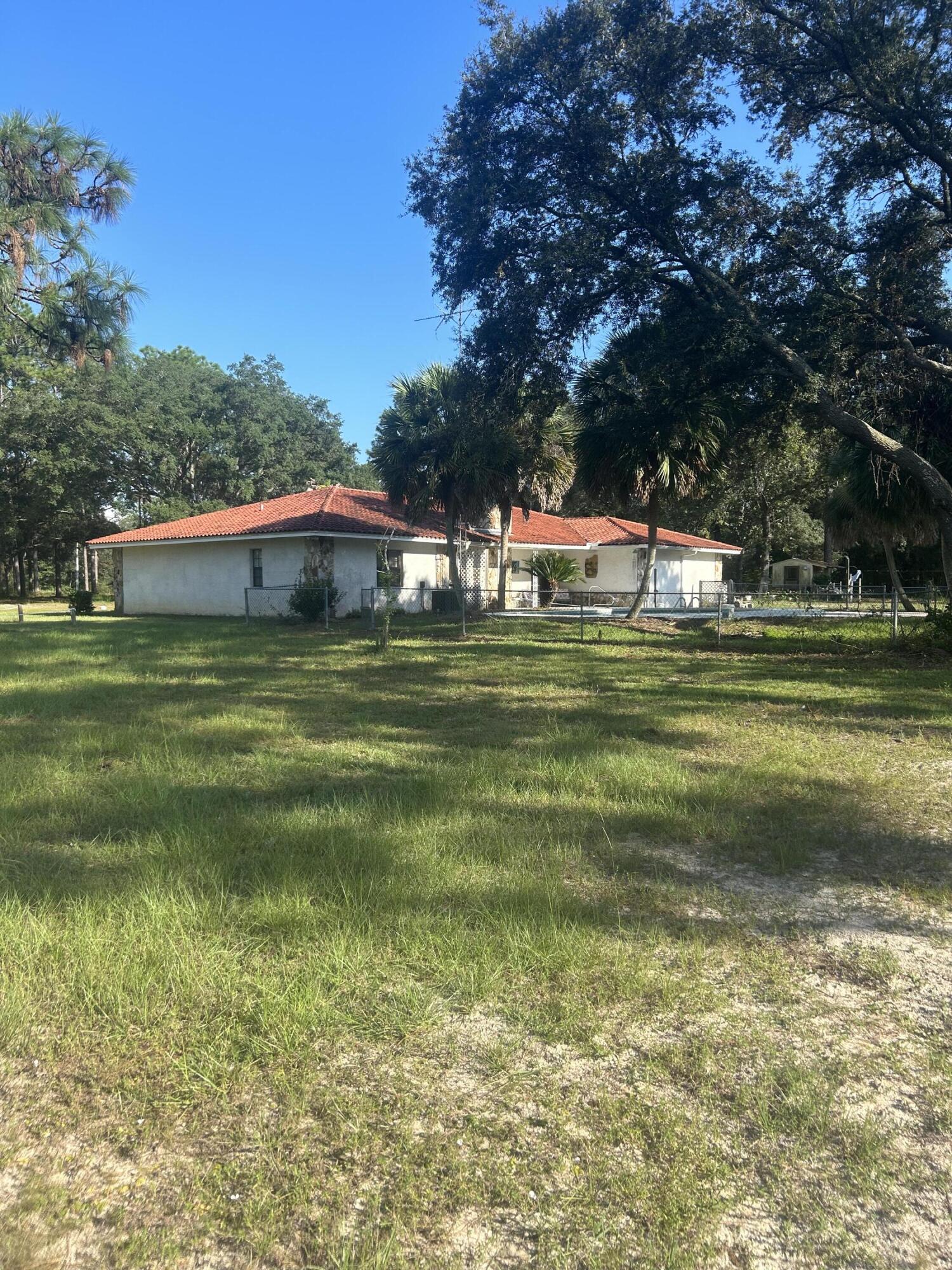329 Sunflower Lane Freeport, FL 32439 - Photo 24 of 39 a backyard of a house with a garden and plants