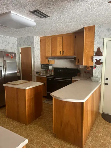 a kitchen with stainless steel appliances granite countertop a sink a stove and a refrigerator