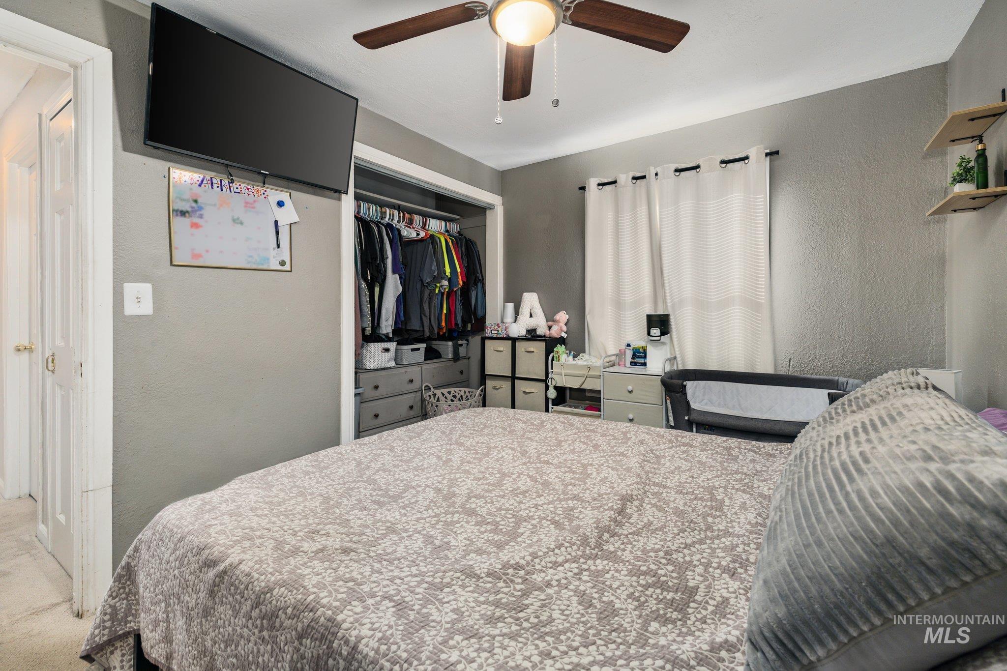 1504 2nd Street North Nampa, ID 83687 - Photo 17 of 29 Bedroom with a textured wall, a closet, carpet floors, and a ceiling fan