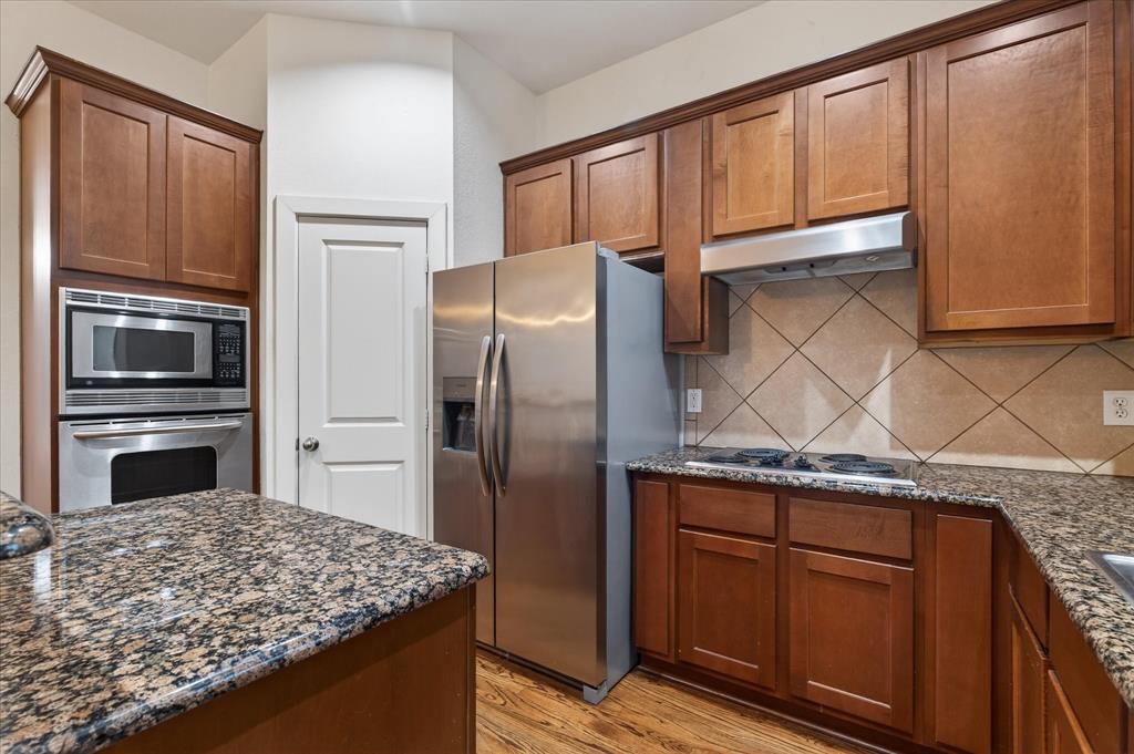 4105 Lafayette Street Dallas, TX 75204 - Photo 15 of 26 a kitchen with granite countertop stainless steel appliances a refrigerator and a stove top oven