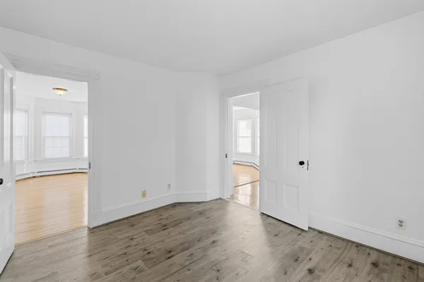 an empty room with wooden floor and closet