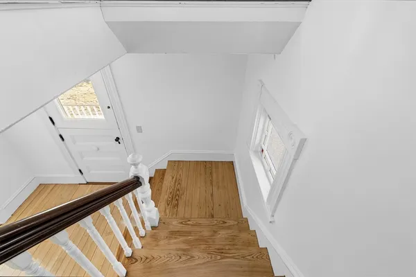 a view of empty room with wooden floor and window