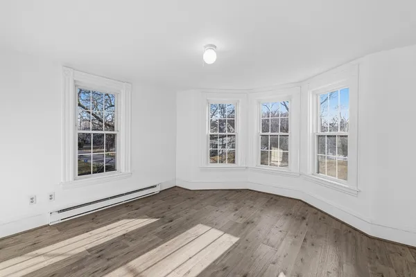 a view of a room with wooden floor and natural light